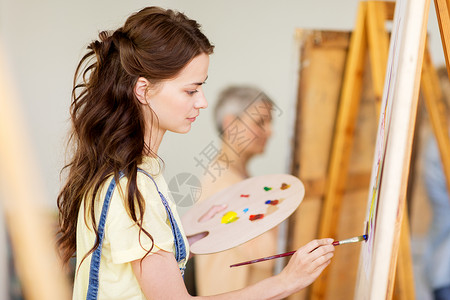 艺术学校,创造力人的学生女孩轻的女艺术家与画架,调色板油漆画笔工作室艺术学校画架的学生女孩生活方式高清图片素材