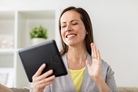 人,技术线交流快乐的女人坐沙发上与平板电脑电脑视频聊天家快乐的女人家平板电脑上视频聊天网络高清图片素材