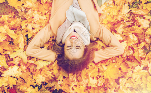 叶子上女孩季节人的美丽的轻女人躺地上秋天的叶子上美丽快乐的女人躺秋叶上背景