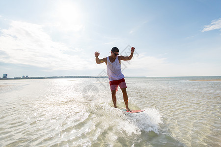 脱脂,水上运动人们的快乐的轻人骑脱脂板上的夏季海滩轻人骑夏季海滩的脱脂板上背景图片