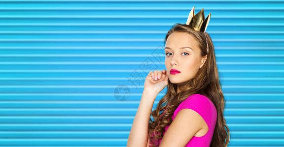 这个傲慢女人人,假日时尚的轻的女人十几岁的女孩穿着粉红色的衣服公主皇冠的蓝色肋背景穿粉红色连衣裙的轻女人少女背景