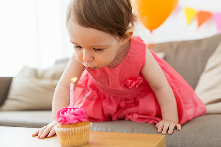 童,人庆祝快乐的女婴蜡烛蛋糕上生日聚会家里生日时蜡烛的女孩图片