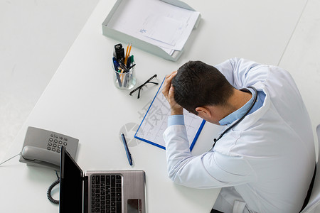 医学,医疗人的医生与心脏图剪贴板笔记本电脑保持头部桌子诊所诊所心电图笔记本电脑的医生办公室高清图片素材
