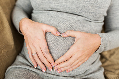 怀孕,爱人的靠近孕妇她的腹部心脏手势孕妇腹部心脏手势图片