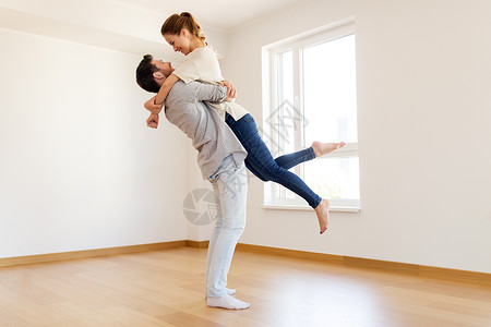 抵押贷款,人房地产的幸福的夫妇拥抱空房间的新家幸福的新家的空房间图片