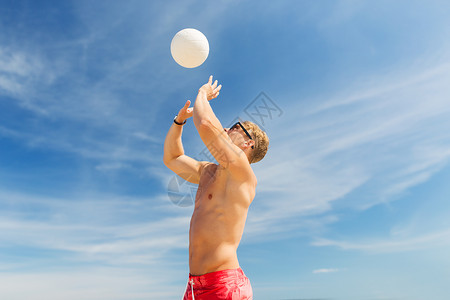 夏天健身的轻人海滩上打沙滩排球图片