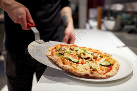 食物烹饪,烹饪人的厨师包师把比萨饼果皮盘子比萨饼店披萨店用烤披萨皮饼背景图片