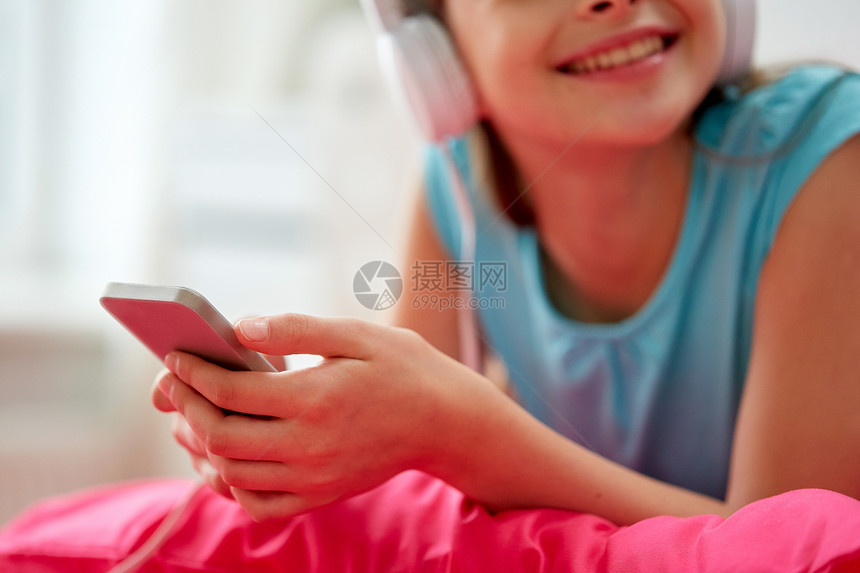 人,孩子,技术休闲快乐的女孩戴着耳机躺床上,家听音乐戴耳机的女孩家听音乐图片