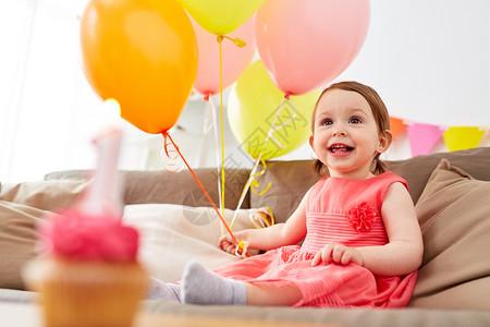 童,假期人的快乐的女婴气球花环生日聚会家里快乐的女婴家里的生日聚会上女的高清图片素材