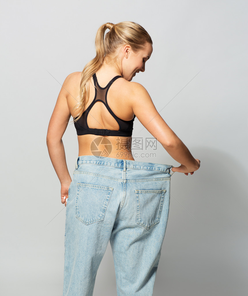 健身,饮食,减肥人的轻的苗条运动妇女穿着超大的裤子穿着超大裤子的轻苗条运动女人图片