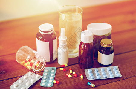 医疗保健医药制药药物药丸鼻喷雾剂退热糖浆木桌上的璃木制桌子上的药物药物背景图片