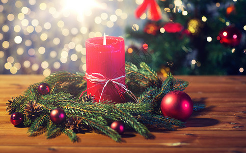 诞节装饰假日广告木板上用红色燃烧蜡烛天然绿色冷杉枝花环木桌上蜡烛的杉枝花环冬天高清图片素材