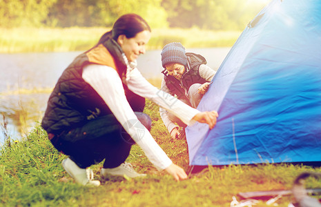 旅游,徒步旅行家庭观念快乐的母子户外搭帐篷快乐的母子户外搭帐篷图片