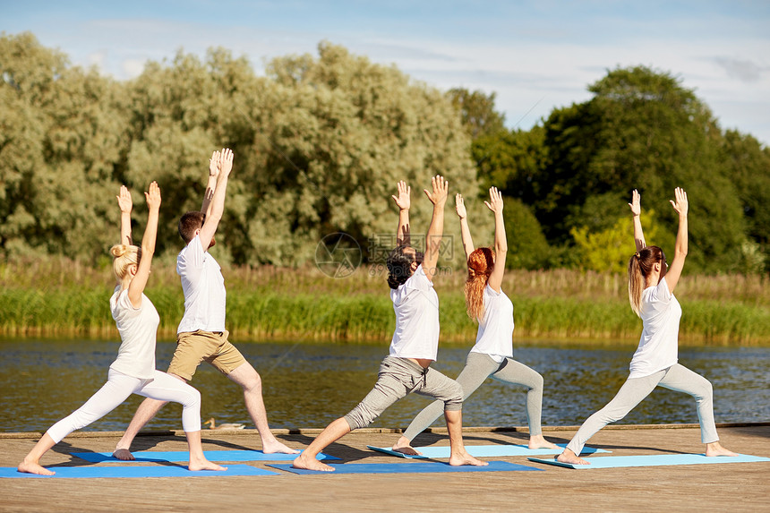 健身,运动,瑜伽健康的生活方式群人河边高弓步新月姿势群人户外瑜伽练图片
