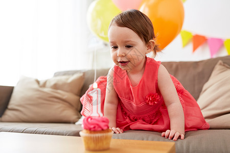 童,假期人的快乐的女婴与纸杯蛋糕生日聚会家里带生日蛋糕的女婴家聚会图片