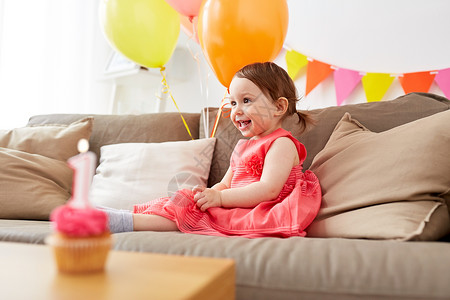 童,假期人的快乐的女婴气球花环生日聚会家里快乐的女婴家里的生日聚会上蹒跚学步的孩子高清图片素材