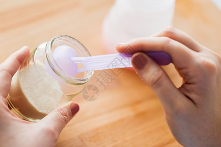 食物营养母亲的手与罐婴儿配方奶粉勺子准备婴儿牛奶用罐子铲子制作配方奶图片