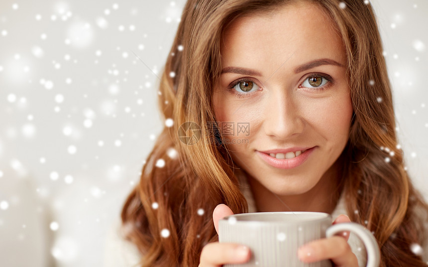 休闲,饮料,冬天人们的靠近快乐的轻女人,喝杯咖啡茶雪地上靠近快乐的女人,雪地上着咖啡杯图片