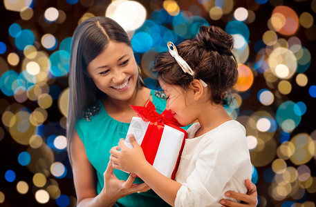 节日,礼物人的快乐的母亲孩子女孩与礼品盒灯光背景带礼品盒的快乐母女图片