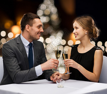 庆祝,人节日的微笑的夫妇诞树背景下的餐厅碰杯非酒精泡酒诞节含酒精的香槟背景图片