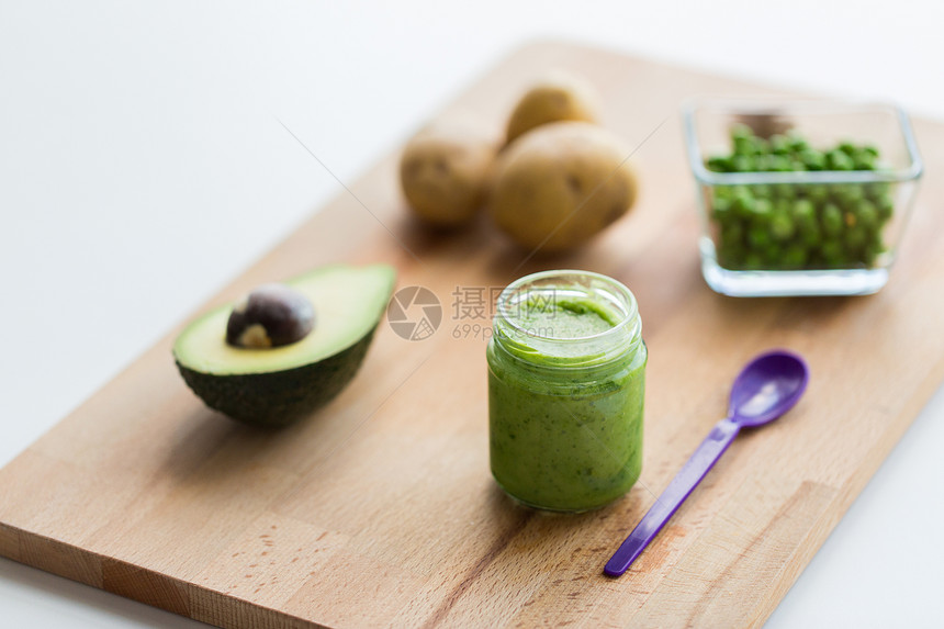 婴儿食品,健康饮食营养璃罐与绿色蔬菜泥木制切割板木板上果泥婴儿食品的罐子图片