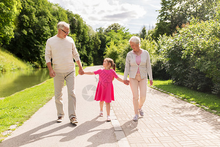 家庭世代人的快乐的微笑祖母,祖父小孙女公园散步公园的祖父母孙女图片
