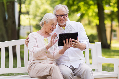 老,技术人的快乐的老夫妇与平板电脑电脑视频聊天夏季公园资深夫妇与视频聊天平板电脑公园应用程序高清图片素材