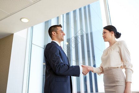 商业,伙伴关系人的微笑的男人女人办公室握手微笑的商人办公室握手图片