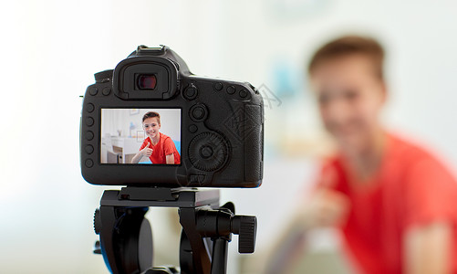 视频日志博客,技术人的相机记录视频快乐的微笑博客男孩家里竖大拇指家庭中博主男孩的相机录制视频背景
