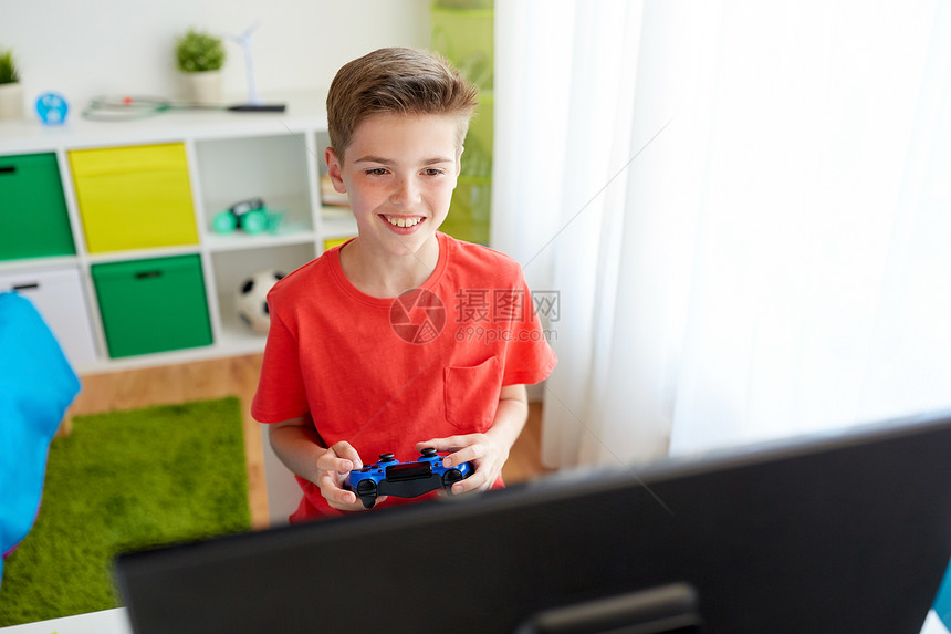游戏,技术人的微笑男孩与游戏电脑玩电子游戏家里电脑上玩电子游戏的游戏玩家男孩图片