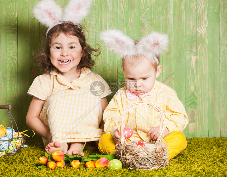 小男孩女孩复活节兔子草地上用五颜六色的鸡蛋复活节兔子宝宝图片