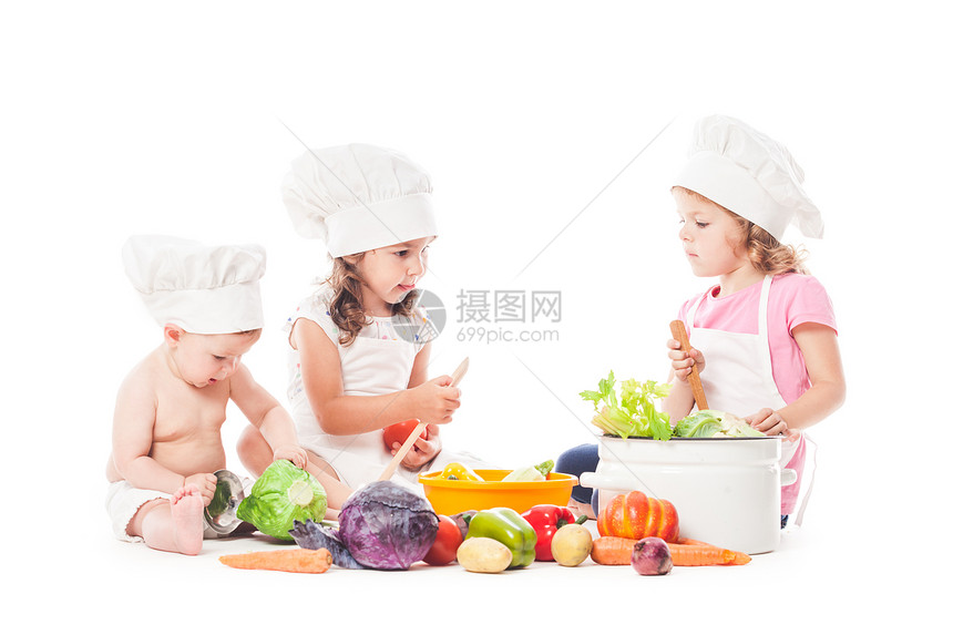 三个孩子玩蔬菜小厨师白色上隔离小厨师饭图片