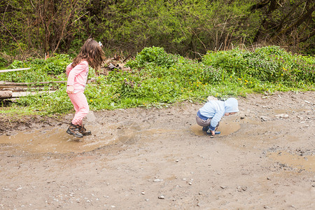 兄妹俩泥坑里玩得很开心为院子玩游戏背景