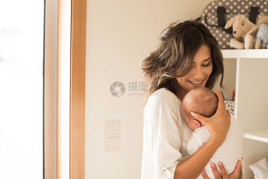 漂亮的女人抱着新生的婴儿图片