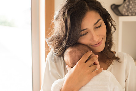 护理学漂亮的女人抱着新生的婴儿背景