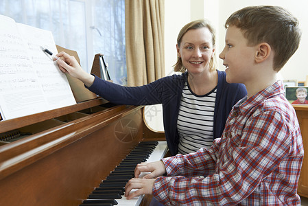音乐老师上钢琴课的男孩幸福的高清图片素材
