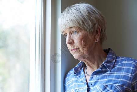 人看窗外患抑郁症的老年女子望着窗外背景