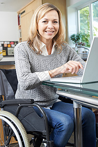 轮椅上的残疾妇女家用笔记本电脑医疗保健高清图片素材