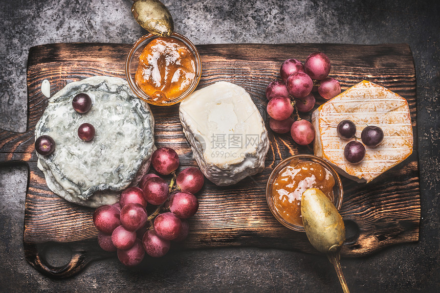 乡村奶酪盘与各种奶酪,葡萄蜂蜜芥末酱,顶部视图黑色的风格图片