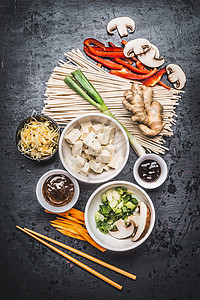 各种亚洲素食烹饪原料筷子与豆腐,条,生姜,切蔬菜,芽,青葱,海鲜奥地利酱汁黑暗的乡村背景,顶部视图绿色高清图片素材
