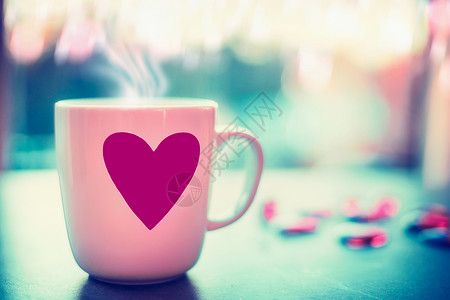 咖啡心可爱的杯子,粉红色的心窗台上,晚上的自然背景与波基,正的爱的象征情人节的背景
