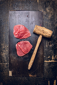 小牛肉施尼泽尔乡村木制背景与旧肉锤高清图片