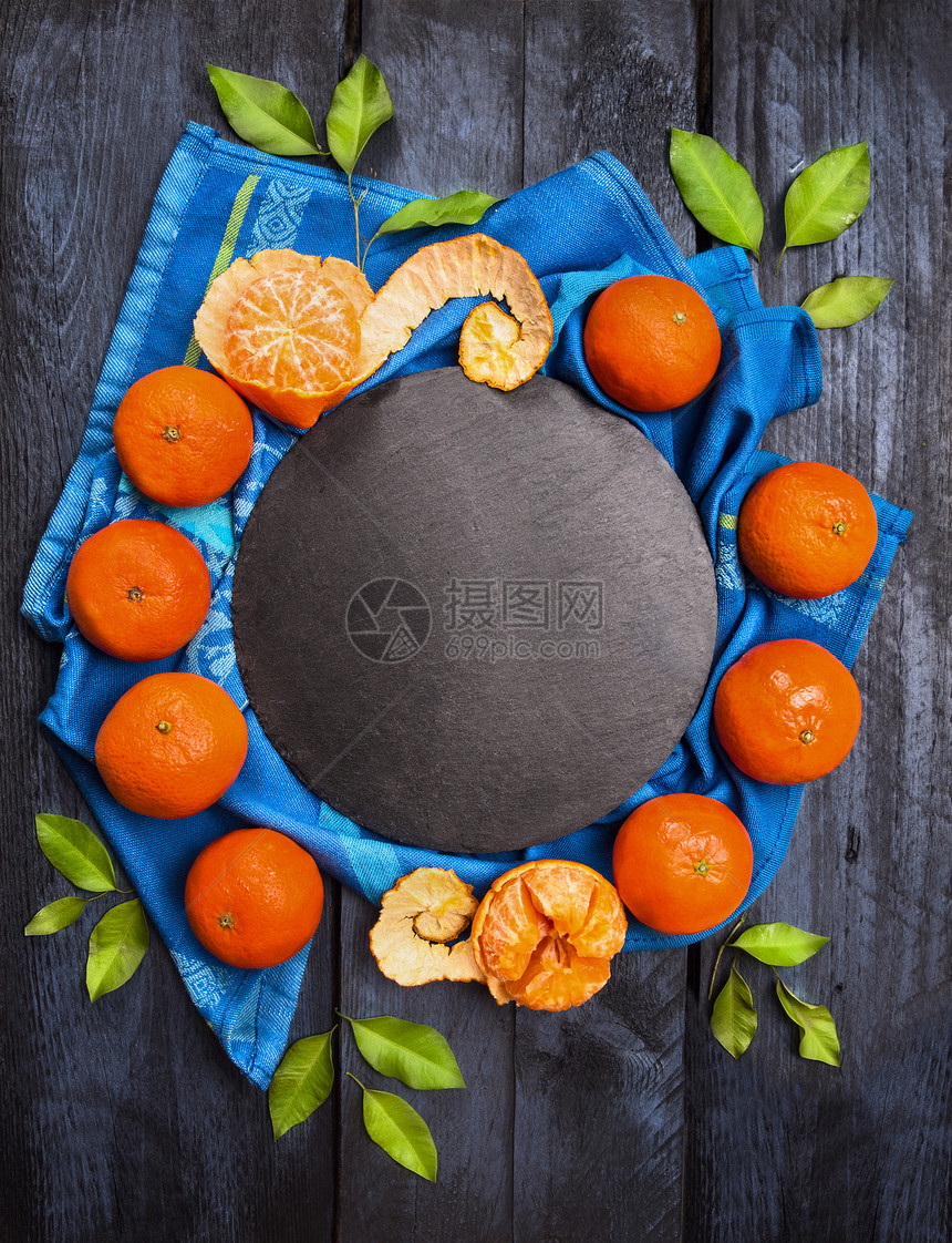 橘子花圈白色绿叶深色木制与石板蓝色毛巾,食物背景,顶部视图图片