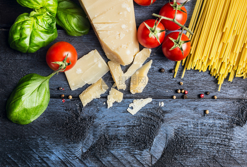 番茄酱意大利的成分罗勒,西红柿,蓝色木制背景上的帕尔马干酪,顶部视图,文字的位置图片