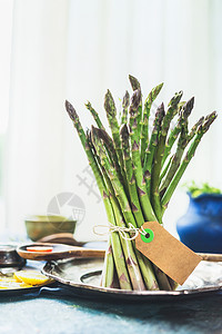 新鲜芦笋与空白标签厨房桌子窗口背景,正视图健康的季节食品图片