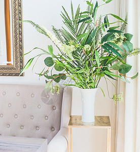 绿色热带房子豪华客厅沙发附近的花瓶里种了植物家居装饰室内图片