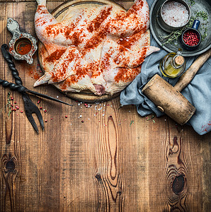 整只鸡木制乡村背景上用调味品厨房工具摊平,烹饪准备,顶部观看鸡肉塔巴卡传统格鲁吉亚菜,高加索菜背景图片
