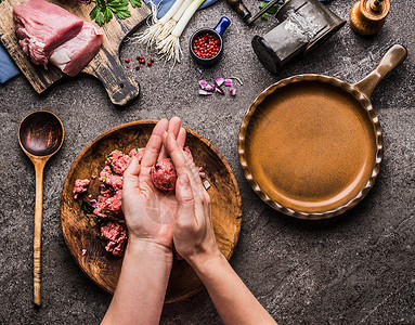 女手厨房桌子背景上用肉肉球,用力肉,绞肉机勺子,顶部视图烹饪,食谱饮食背景图片
