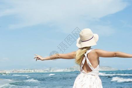 个女人海边城镇享受夏天的微风图片