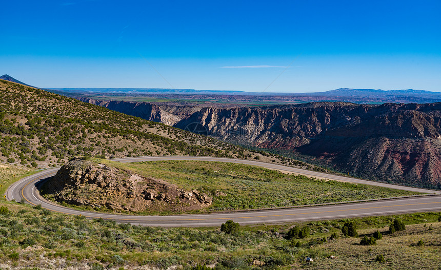 犹他州火焰峡谷绿色河流风景道俯瞰,出红色的山脉高沙漠植物的生命,前景扭曲的公路图片
